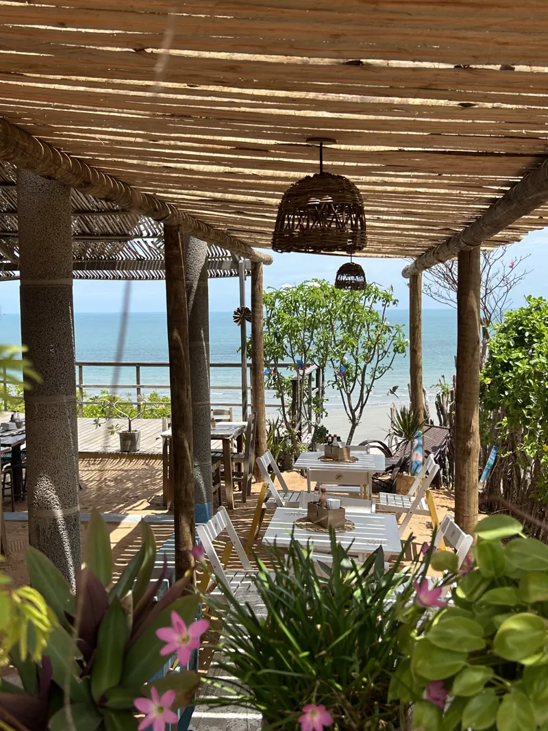 Salão com plantas e vista para o mar